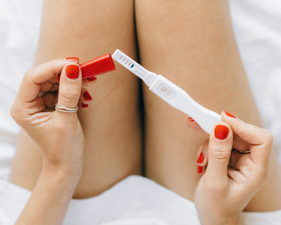 Woman holding pregnancy test.