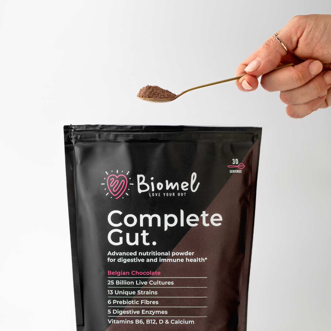 Women holding a serving spoon of Biomel Belgian Chocolate Complete Gut.