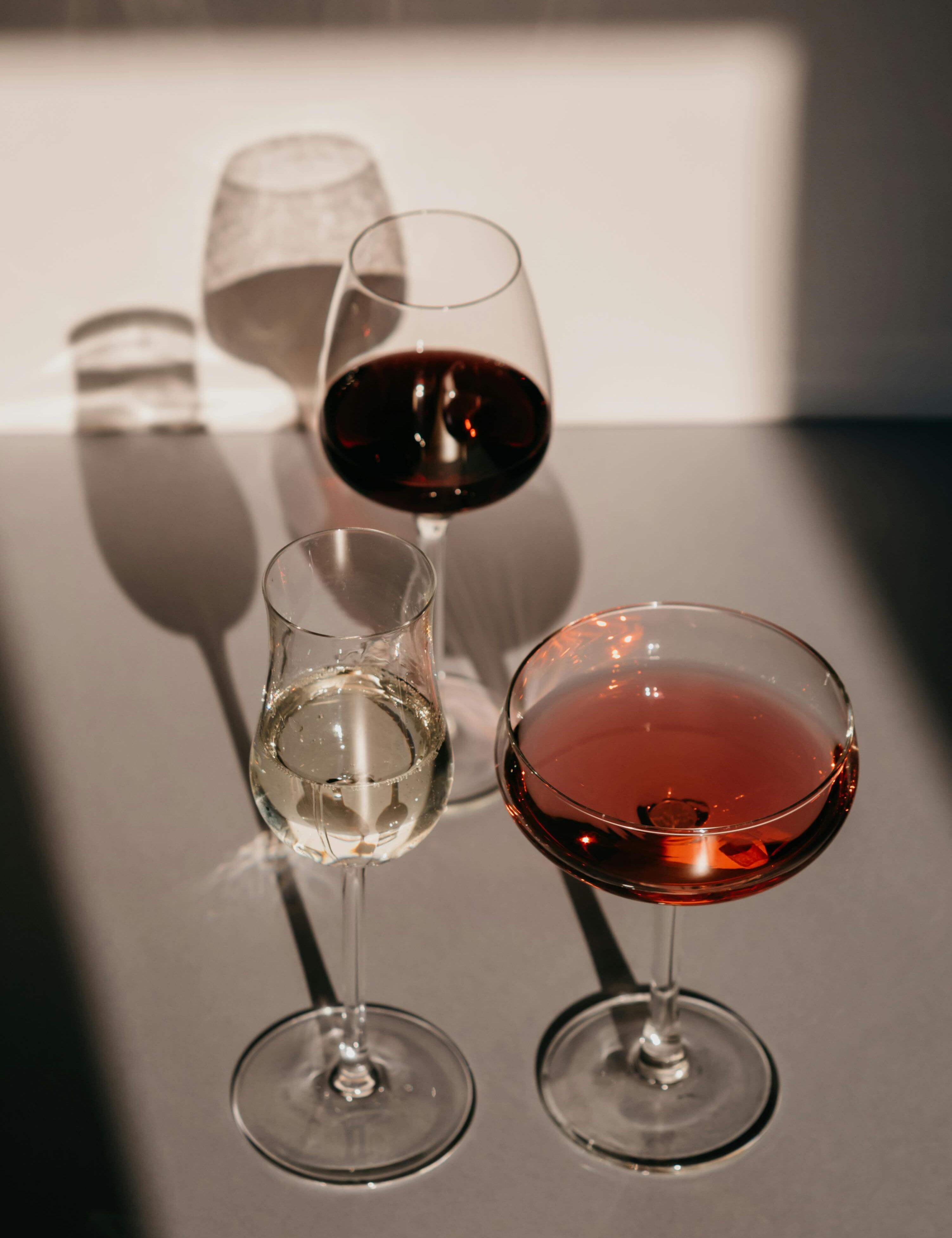 3 glasses of wine with red liquid